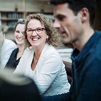 ACTC Trainerin Katja sitzt mit den Teilnehmern am Tisch | Kraus & Partner