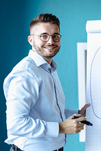 Junior Consultant Sebastian steht am Flipchart und erklärt Agilität | Kraus & Partner