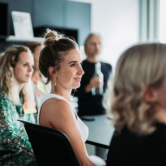Teilnehmer des Agile Awareness Workshops sitzen am Tisch und hören dem Sprecher zu | Kraus & Partner