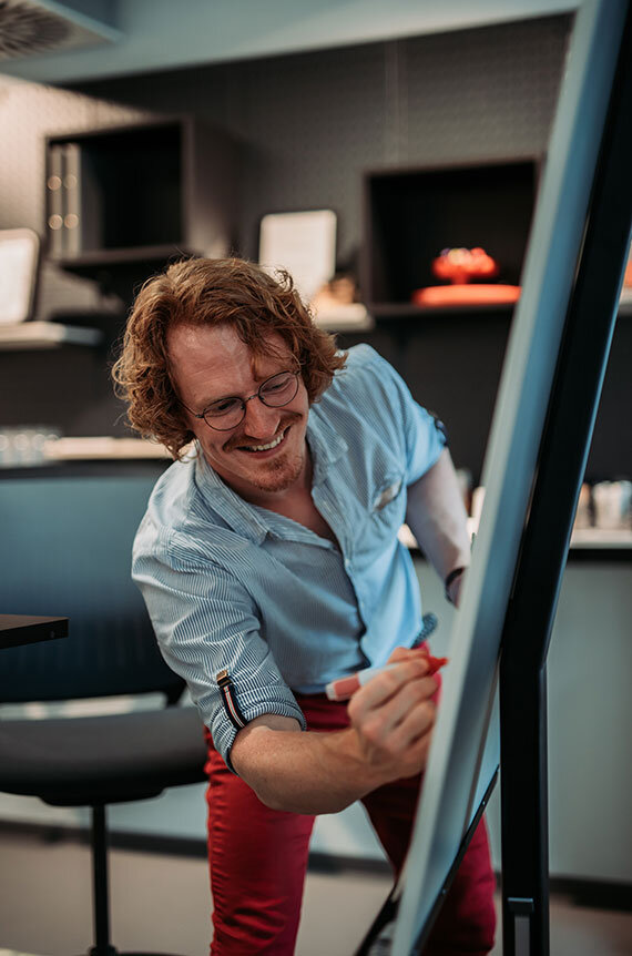 Sebastian notiert Ergebnisse des Agile Awareness Workshops am Flipchart | Kraus & Partner