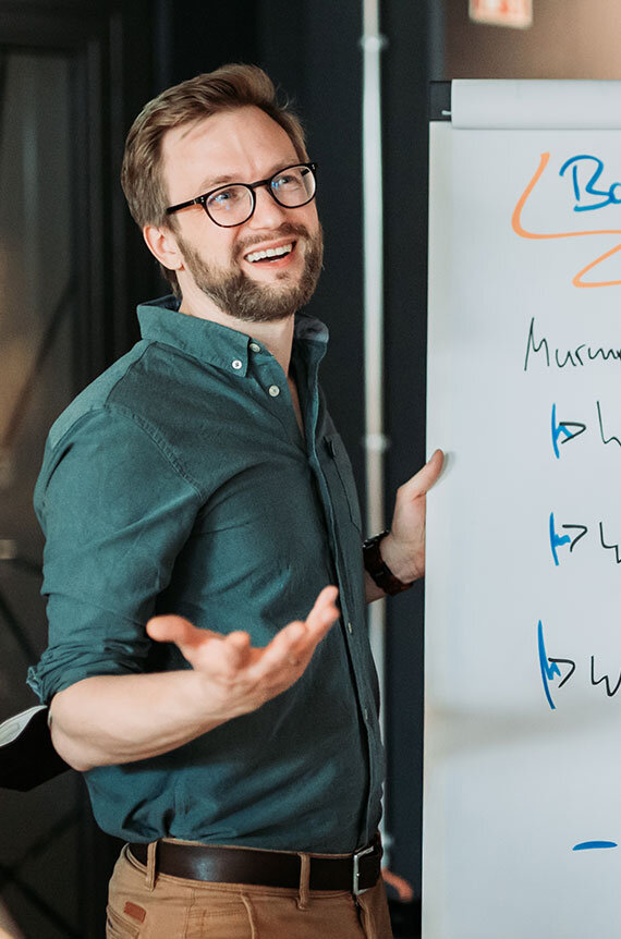 Bastian steht am Flipchart und erklärt Agiles Projektmanagement | Kraus & Partner