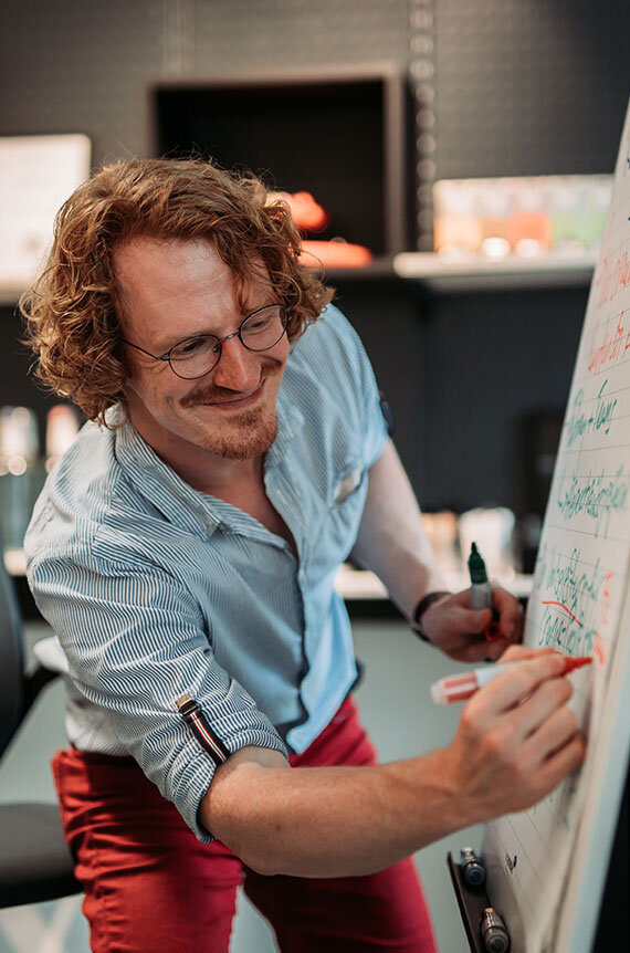 Berater Sebastian notiert etwas während des Kreativworkshops am Flipchart | Kraus & Partner