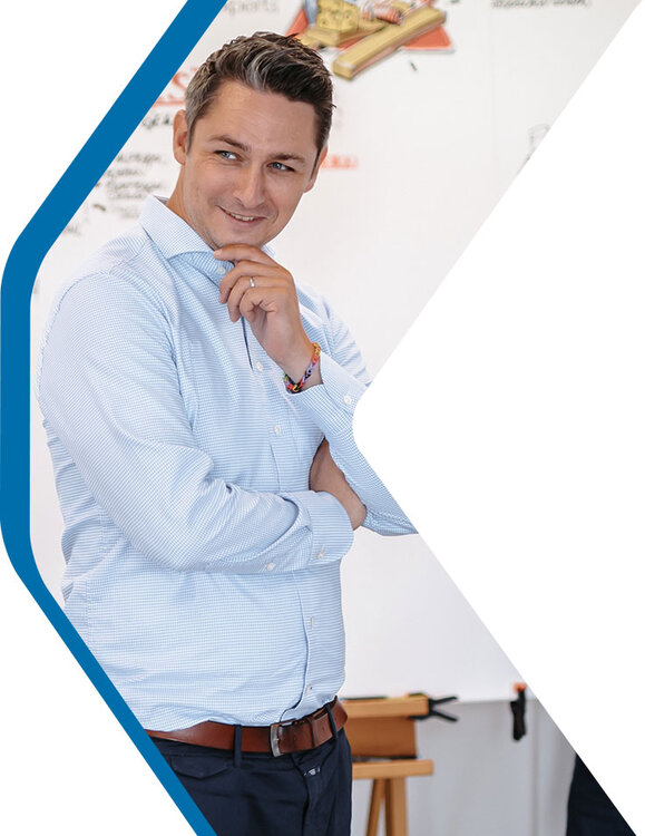 Transformation Experte Max lachend vor einem Flipchart zum Thema Change Management | Kraus & Partner - Transformation Experts