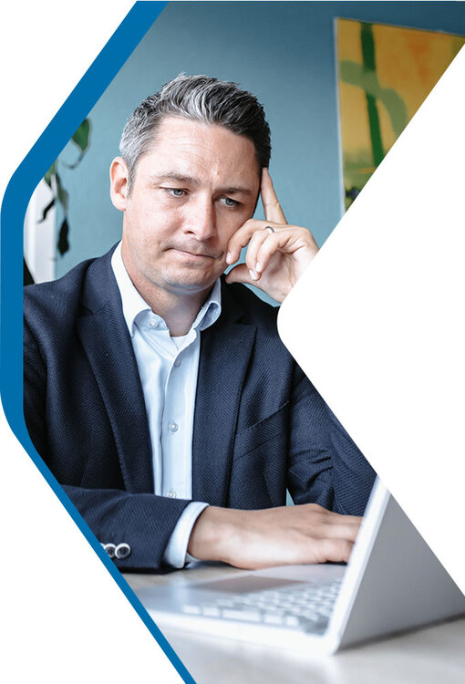 Transformation Experte Max erarbeitet konzentriert am Laptop eine Strategie | Kraus & Partner - Transformation Experts