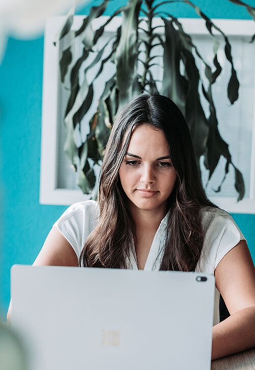 Kollegin sitzt am Laptop | Kraus & Partner - Transformation Experts