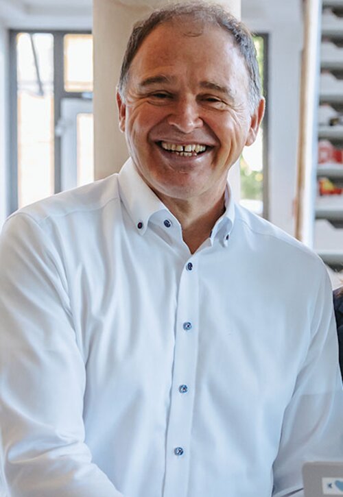 Berater lächelt während Gespräch | Kraus & Partner - Transformation Experts