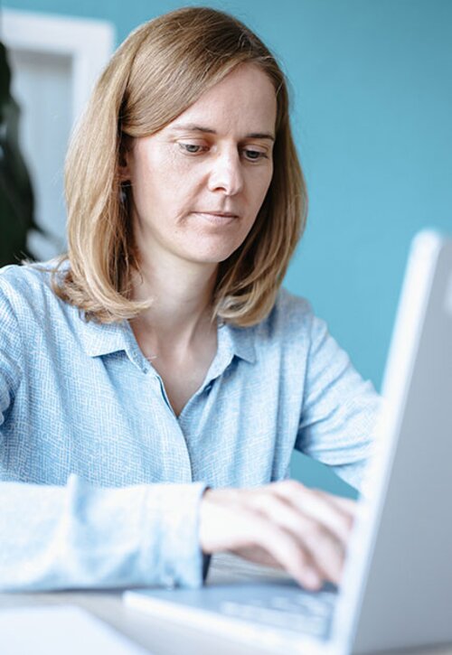 Unsere Beraterin Katharina am Laptop zum Thema Lean Management  | Kraus & Partner - Transformation Experts