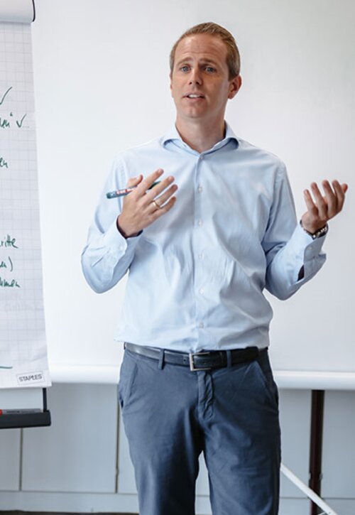 Consultant Kevin steht vor einer Flipchart | Kraus & Partner - Transformation Experts